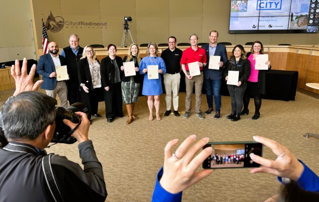 Redmond mayor and space industry representatives display copies of proclamation